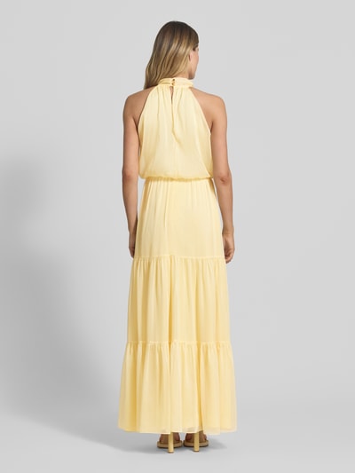 Frauenmodel trägt Abendkleid mit floraler Applikation von Swing aus gelbem Chiffon, Maxikleid, Taillierter Schnitt, Volantsaum, rückseitiger Schlüsselloch-Ausschnitt mit Knöpfen und Reißverschluss, Rückenlänge bei Größe 36: 112 cm, Brustweite 33 cm, Ganzkörperansicht Rückansicht.