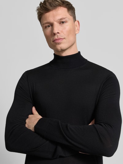 Męski model nosi Sweter z golfem z wełny merino Model 'TRAY' od SELECTED HOMME, czarny, dopasowany krój, prążkowane wykończenia, nahaufnahme oberkörper.
