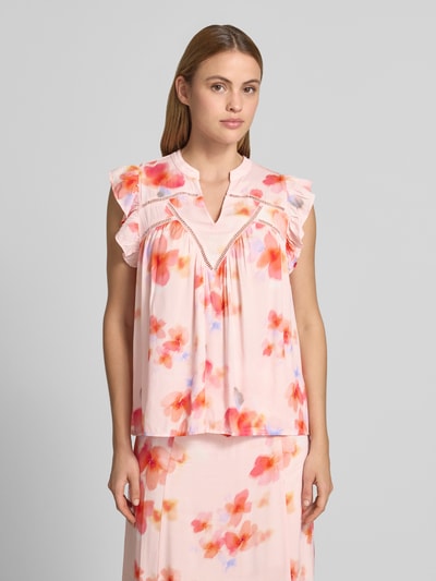 Frauenmodel trägt Blusentop aus Viskose mit V-Ausschnitt Modell 'Mirava' von mbyM, Regular-Fit, Rüschen, florales Muster, Nahaufnahme Oberkörper. Rückenlänge bei Größe S: 61 cm, Ärmellänge: 8 cm.