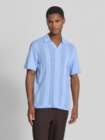 Männermodel trägt Relaxed Fit Poloshirt aus reiner Baumwolle von Armedangels, Optik: Unifarben, Feinstrick, Ganzkörperansicht von vorne.