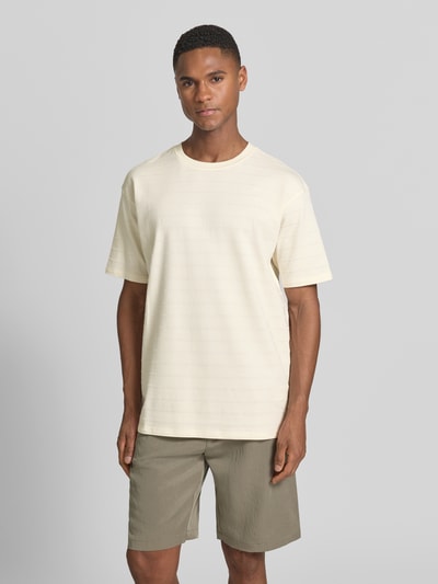 Männermodel trägt T-Shirt mit Strukturmuster und Rundhalsausschnitt von Scotch & Soda, Baumwoll-Elasthan-Mix, Relaxed-Fit, Ganzkörperansicht von vorne.
