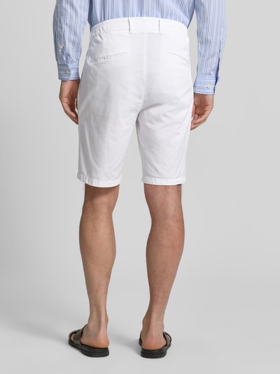 Męski model nosi jednokolorowe szorty bermudy Relaxed Fit bermudy aus baumwoll-mix Modell 'TINO' von Brax z mieszanki bawełny, szlufki na pasek, kieszenie boczne; widok całej sylwetki od tyłu.