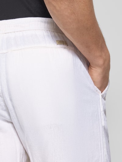 Männermodel trägt Shorts aus Leinen-Viskose-Mix Modell 'MALVIN' von Blend, weiße Farbe, sichtbare Struktur, Nahaufnahme Hüfte Rückansicht, Regular Fit, elastischer Bund, Eingrifftaschen, Bundweite 37 cm, Innenbeinlänge 23 cm.