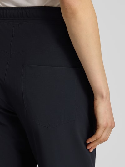 Frauenmodel trägt Hose mit Tunnelzug Modell 'JUNE' von Cambio, dunkelblauer Material-Mix mit Stretch, Detailaufnahme Rückansicht