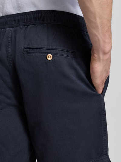 Männermodel trägt Regular Fit Shorts mit elastischem Bund Modell 'SUNFADED' von Gant aus Reine Baumwolle in Dunkelblau, Detailaufnahme Rückansicht. Herren Shorts, Regular-Fit, mit Tunnelzug, Bundweite bei Größe M 43 cm, Innenbeinlänge 15 cm.