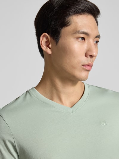 Männermodel trägt Regular Fit T-Shirt aus reiner Baumwolle von Tom Tailor in Mintgrün mit V-Ausschnitt, Nahaufnahme Oberkörper.