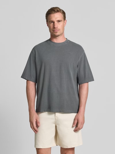 Männermodel trägt Boxy Fit T-Shirt aus reiner Baumwolle Modell 'CORY' von Selected Homme, grauer Farbton, Herren T-Shirt, Ganzkörperansicht von vorne.