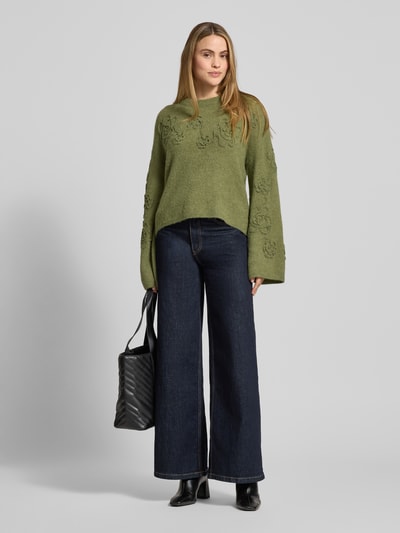 Frauenmodel trägt Strickpullover mit Stitchings Modell 'Miabelle Hope' von MSCH Copenhagen in Grün, Relaxed Fit, Ganzkörperansicht von vorne.