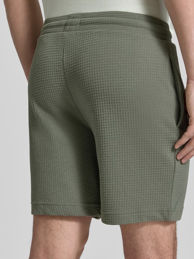 Männermodel trägt Regular Fit Sweatshorts aus Baumwoll-Mix Modell 'AUSTIN' von HUGO, Optik: Unifarben, Waffelstruktur, Ganzkörperansicht Rückansicht.