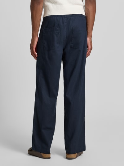 Männermodel trägt dunkelblaue Regular Fit Hose aus Leinen-Baumwoll-Mix Modell 'barton' von Matinique, elastischer Bund, Ganzkörperansicht Rückansicht. Herren Hose, Bundweite 42 cm, Innenbeinlänge 81 cm, Größe M.
