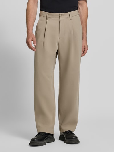 Männermodel trägt Wide Leg Bundfaltenhose mit Viskose-Anteil von Jake*s, unifarben beige, feines Webmuster, Ganzkörperansicht von vorne.