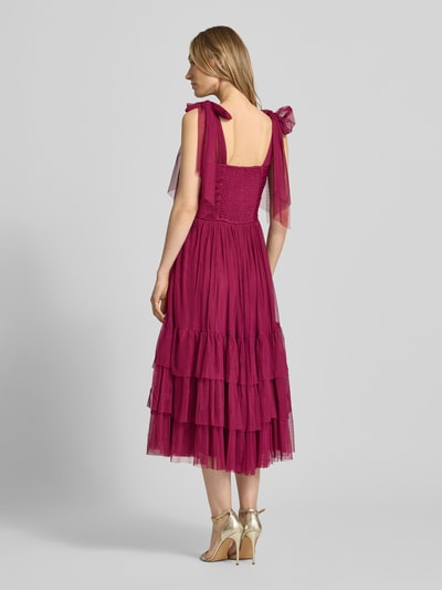 Modelka nosi Knielanges Cocktailkleid im Stufen-Look von LACE & BEADS, malinowy kolor, mesh, A-linia, drapowania, długość do kolan, długość tyłu w rozmiarze S: 104 cm, szerokość w rozmiarze S: 40 cm, widok całej sylwetki z tyłu.