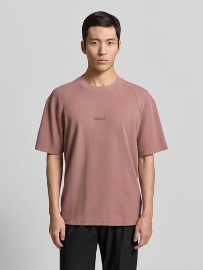 Männermodel trägt Regular Fit T-Shirt aus reiner Baumwolle Modell 'DAFFL' von HUGO in Unifarbe mit Strukturmuster, Nahaufnahme Oberkörper.