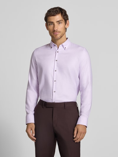 Männermodel trägt Slim Fit Businesshemd aus reiner Baumwolle von Seidensticker in hellem Flieder und brauner Hose, Ganzkörperansicht von vorne.