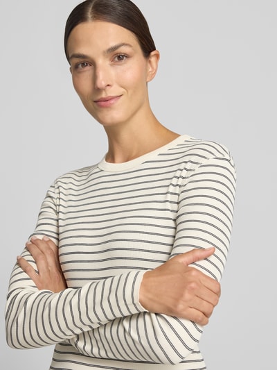 Frauenmodel trägt Slim Fit Longsleeve aus reiner Baumwolle Modell 'NURIT' von DRYKORN, weiß mit schwarzen Streifen, Rundhalsausschnitt, Nahaufnahme Oberkörper.