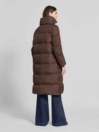 Frauenmodel trägt Regular Fit Daunenmantel mit abnehmbaren Rucksackriemen von Marc O'Polo in Braun, gesteppte Oberfläche, Ganzkörperansicht Rückansicht. Damen Daunenmantel von Marc O'Polo.