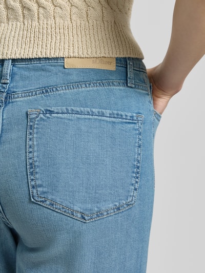 Kobieta nosi Straight Fit Jeans aus Baumwoll-Mix Modell 'KAROLIN' od s.Oliver RED LABEL, dżinsowa optyka, średni stan, krój straight leg, długość cropped, label patch, nit, szlufki na pasek, zapięcie na guzik i ukryty zamek, 5 kieszeni, materiał: mieszanka bawełny, zbliżenie na tył.