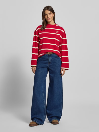 Frauenmodel trägt Wide Leg Jeans aus reiner Baumwolle von Tommy Hilfiger in Denim-Optik mit Kontrastnähten, Label Patch, 5-Pocket-Design, High-Waist-Fit, Nieten und Knopfverschluss, Ganzkörperansicht von vorne.