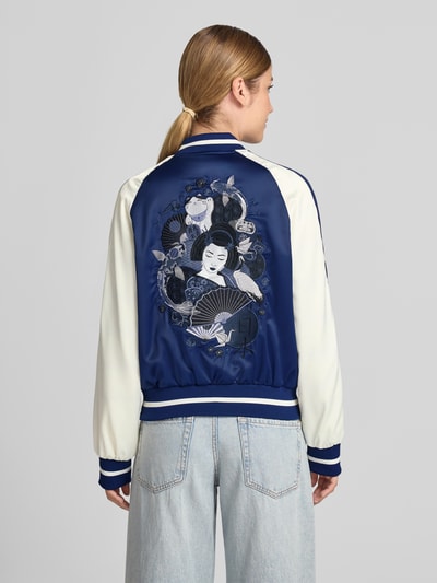 Frauenmodel trägt Bomberjacke mit Label-Detail von Original Bombers, blau-weiß, Material-Mix, Regular Fit, Rückenansicht, ganzkörper.