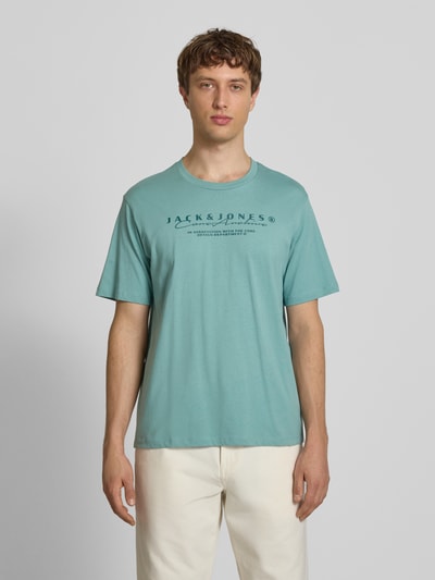 Männermodel trägt T-Shirt mit Logo und Rundhalsausschnitt von Jack & Jones aus Reine Baumwolle im Regular-Fit in Türkis, Ganzkörperansicht von vorne. Rückenlänge bei Größe M: 71 cm.