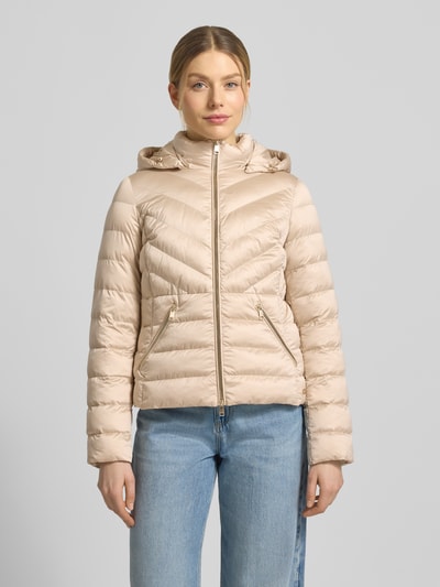 Frauenmodel trägt taillierte Steppjacke mit Zweiwege-Reißverschluss Modell 'ANYA' von Beaumont Amsterdam in Beige mit Kapuze, Ganzkörperansicht von vorne. Damen Steppjacke, Schnitt tailliert, Rückenlänge 55 cm, Schulterbreite 38 cm, Brustweite 48 cm, Ärmellänge 61 cm.