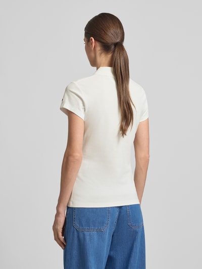 Frauenmodel trägt Slim Fit Poloshirt aus Baumwoll-Mix von Tommy Hilfiger in Unifarbe mit Logo-Stitching, Piqué-Struktur, Ganzkörperansicht Rückansicht.