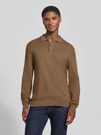 Męski model nosi Regular Fit Strickpullover aus Baumwoll-Mix mit Kaschmir-Anteil od Casual Friday, kolor brązowy, kołnierzyk polo, elastyczne wykończenia, mieszanka bawełny i kaszmiru, długość tyłu w rozmiarze M: 65 cm, długość rękawów: 69 cm, widok całej sylwetki z przodu.