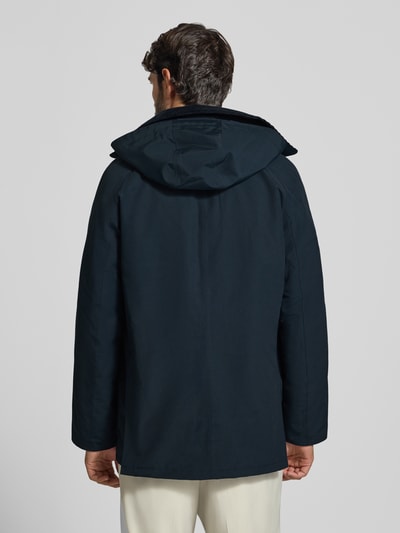 Männermodel trägt Regular Fit Funktionsjacke mit Kapuze von Barbour in unifarbenem matt schwarz mit Struktur, Ganzkörperansicht Rückansicht.