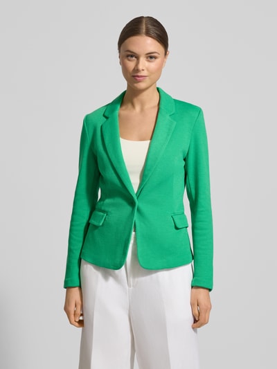 Kobiece modelka nosi Regular Fit Kurzblazer mit Baumwoll-Anteil Modell 'JULIA' von Vero Moda, efekt: jednolity kolor, krój regular fit, kołnierz z połami, zapięcie na 1 guzik, długi rękaw, zakończenie rękawów: nachodzące na siebie guziki, kieszenie z patką, wykończenie materiału: pika, jasny zielony, gładka tekstura, widok całej sylwetki z przodu.