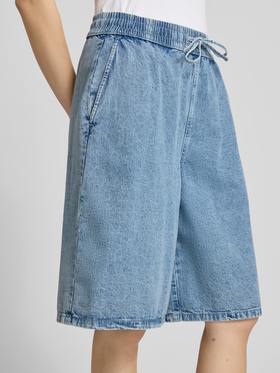 Frauenmodel trägt Jeansshorts mit weitem Bein Modell 'SIGNE' von Noisy May aus reiner Baumwolle in Hellblau, Nahaufnahme Oberkörper.