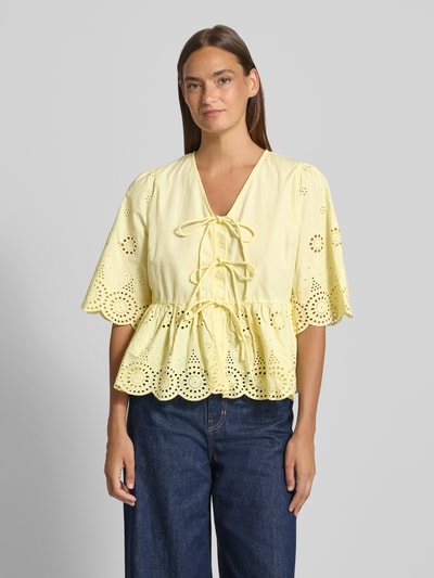 Modelka nosi bluzkę z bawełny ekologicznej YAS Bluse mit Lochstickerei und Schnürung Modell 'CORNELIA', żółta, haft angielski, krój taliowany, dekolt w serek, dół obszyty falbaną, długość tyłu w rozmiarze 36: 56 cm, długość rękawów w rozmiarze 36: 37 cm, widok całej sylwetki z przodu.