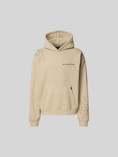 Männermodel trägt Oversized Hoodie aus Baumwoll-Mix von Don´t Waste Culture in Beige mit Florale-Stickereien, Känguru-Tasche, elastische Abschlüsse, Rückenlänge 70 cm, Ganzkörperansicht von vorne.