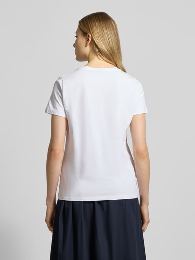 Frauenmodel trägt T-Shirt mit Rundhalsausschnitt und Perlen von More & More, weißer Baumwoll-Elasthan-Mix, Regular Fit, Ganzkörperansicht Rückansicht.