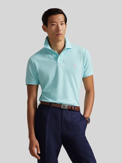 Männermodel trägt Regular Fit Poloshirt aus reiner Baumwolle von Polo Ralph Lauren in Hellblau, unifarben, Polokragen, Logo, Piqué-Textur, Ganzkörperansicht von vorne.