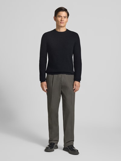 Männermodel trägt Strickpullover aus Kaschmir mit Rundhalsausschnitt von FTC Cashmere, grob gestrickt, ganzkörperansicht von vorne.
