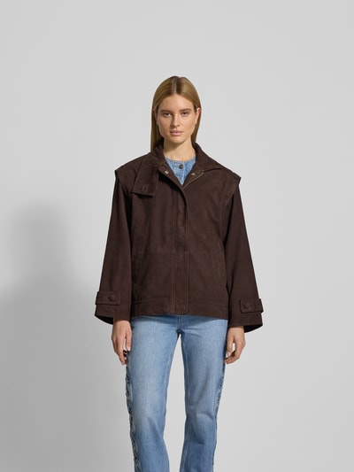 Frauenmodel trägt Oversized Jacke mit Stehkragen von ROTATE aus braunem Ziegenvelours mit Ärmelriegeln und verdecktem Reißverschluss, Ganzkörperansicht von vorne. Rückenlänge 70 cm, Brustweite 63 cm, Ärmellänge 57 cm bei Größe 36.