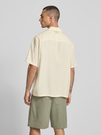 Männermodel trägt Freizeithemd aus Lyocell-Mix von Maison Kitsune in Beige, Relaxed Fit, kurzärmelig, Reverskragen, Rückenansicht, Ganzkörperansicht Rückansicht.