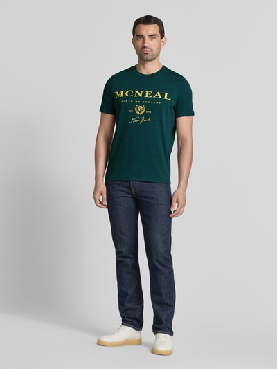 Męski model nosi T-Shirt mit Label-Print und Rundhalsausschnitt von MCNEAL, zielony, bawełna, krój regular fit, długość tyłu 68 cm, Ganzkörperansicht von vorne.
