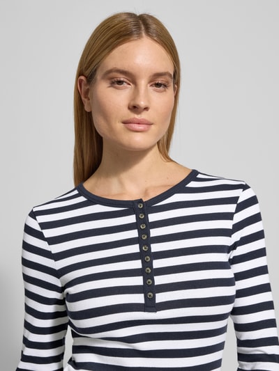Vrouwenmodel draagt Shirt met lange mouwen met korte knoopsluiting van Christian Berg Woman, mix van biologisch katoen met stretch, slim fit, geribde ronde hals, wit met donkerblauwe strepen, Nahaufnahme Oberkörper.