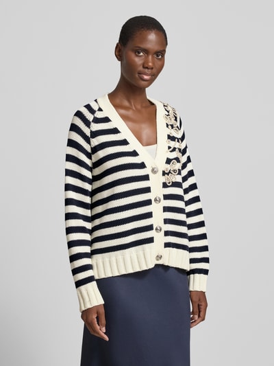 Frauenmodel trägt Relaxed Fit Cardigan mit Ziersteinbesatz von Liu Jo White in gestreifter Strick-Optik, V-Ausschnitt, Knopfleiste, floraler Zierbesatz, elastische Abschlüsse, Baumwoll-Mix, Rückenlänge 59 cm, Ärmellänge 70 cm, Ganzkörperansicht von vorne.