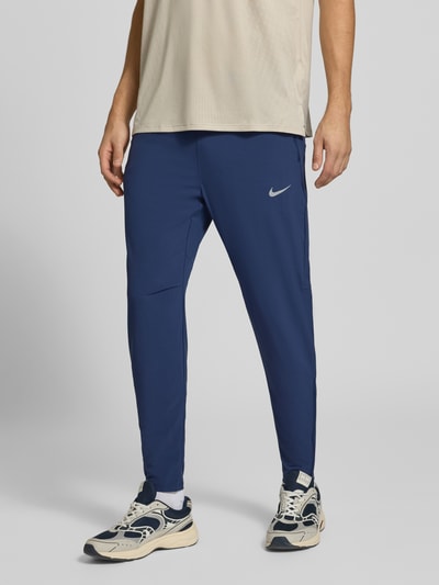 Männermodel trägt dunkelblaue Slim Fit Trainingshose mit Dri-FIT-Technologie Modell 'Stride' von Nike, Herren Trainingshose, Nahaufnahme Unterkörper.