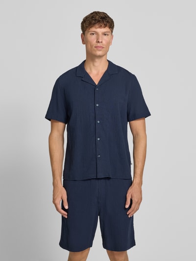 Männermodel trägt Resort Fit Freizeithemd aus reiner Baumwolle von s.Oliver RED LABEL in Dunkelblau mit glatter Struktur, Ganzkörperansicht von vorne.