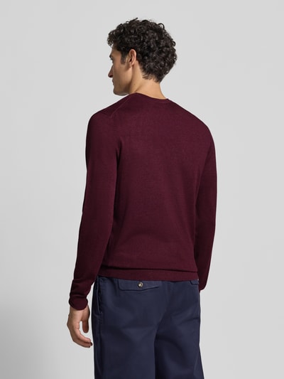 Männermodel trägt Strickpullover mit geripptem Rundhalsausschnitt von MCNEAL in Bordeaux, glatte Textur, Ganzkörperansicht Rückansicht, taillierte Passform, leicht überschnittene Schultern, gerippte Abschlüsse, Rückenlänge und Ärmellänge laut Größe M.