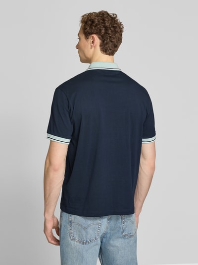 Männermodel trägt Regular Fit Poloshirt aus reiner Baumwolle Modell 'BLOCKS' von BOSS Orange, Dunkelblau, Optik: Unifarben, Ganzkörperansicht Rückansicht.
