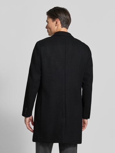 Männermodel trägt Mantel mit Reverskragen und Pattentaschen von Lindbergh, schwarze Farbe, glatte Textur, Ganzkörperansicht Rückansicht. Kontext: Slim Fit, Knopfleiste, Rückenlänge 102 cm, Schulterbreite 40 cm, Brustweite 51 cm, Ärmellänge 65 cm.