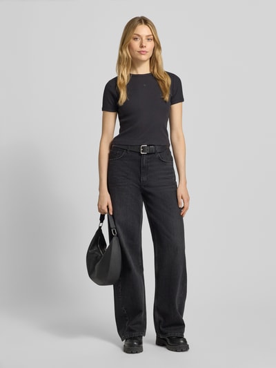Frauenmodel trägt Cropped T-Shirt mit geripptem Rundhalsausschnitt von Scotch & Soda aus Baumwoll-Elasthan-Mix, Slim-Fit, Schwarz, Ganzkörperansicht von vorne.