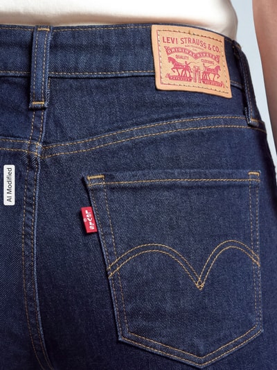 Frauenmodel trägt Bootcut Jeans aus Baumwoll-Mix Modell '315®' von Levi's® 300 in Denim mit Label Patch und 5-Pocket-Design, Nahaufnahme Rückansicht, KI-modifiziertes Bild.
