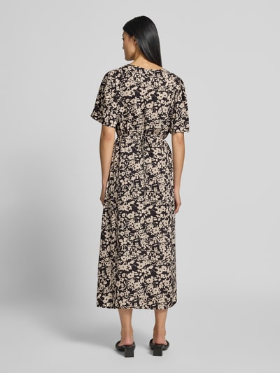 Frauenmodel trägt Tailliertes Freizeitkleid aus reiner Viskose von Marc O'Polo mit floralem Muster in Schwarz und Beige, Ganzkörperansicht Rückansicht. Damen Freizeitkleid von Marc O'Polo