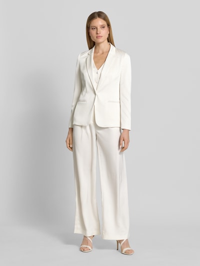 Frauenmodel trägt Slim Fit Blazer mit Paspeltaschen von Jake*s Cocktail in Weiß, Satin, Reverskragen, Knopfverschluss, Ganzkörperansicht von vorne.