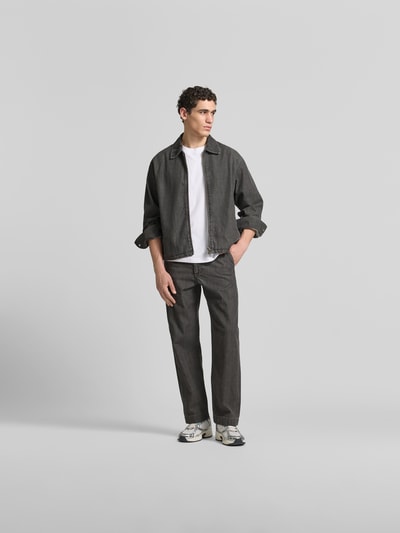 Männermodel trägt Relaxed Fit Jeans aus Baumwoll-Mix von ANNARR in Dunkelgrau mit 5-Pocket-Design, Ganzkörperansicht von vorne.